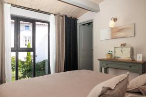 a bedroom with a bed and a window at La Martinoise Patio in Saint-Martin-de-Ré