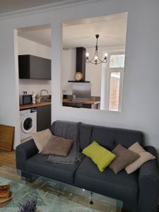 ein Wohnzimmer mit einem Sofa und einer Küche in der Unterkunft MARCELINE in Lannion