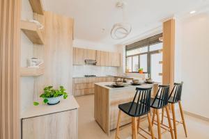a kitchen with wooden cabinets and a island with bar stools at ROOFTOP VIEW APARTMENTS REBERO in Kigali