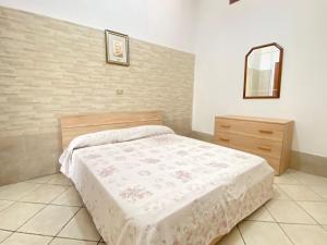een slaapkamer met een bed, een dressoir en een spiegel bij Small House Gallipoli in Gallipoli
