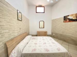 een slaapkamer met een bed en een muur bij Small House Gallipoli in Gallipoli