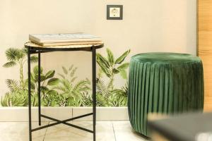 a green stool next to a table and a green drum at IRIS COZY HOUSE με ανεξάρτητη είσοδο in Volos