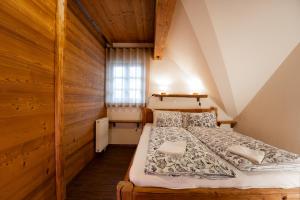 1 dormitorio con 1 cama en una habitación con paredes de madera en Apartments Julijana, en Kranjska Gora