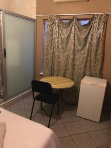 uma mesa e uma cadeira num quarto com uma janela em Good living Guesthouse em Windhoek