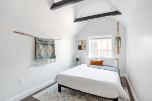 Decompress in the Zen Surroundings of a Cozy Carriage House في واشنطن: غرفة نوم بيضاء بها سرير ونافذة