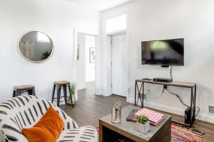 Decompress in the Zen Surroundings of a Cozy Carriage House في واشنطن: غرفة معيشة مع أريكة وتلفزيون