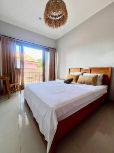 Un dormitorio con una cama grande y una lámpara de araña. en Amigos Guesthouse & Hostel, en Canggu