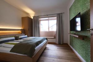 a hotel room with two beds and a flat screen tv at See-Apartments Kärntnerhof in Weissensee