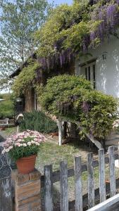 a house with a fence and flowers in front of it at La Locanda Del Molino in Fortunago