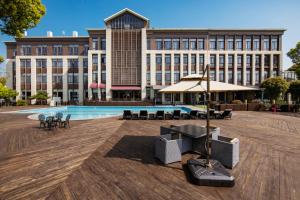 a large building with a pool in front of it at Fondney Hotel Shanghai Hongqiao in Shanghai