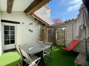 patio con tavolo, sedie e recinzione di Beau T3 *** pour 2 à 4 pers avec patio privatif a La Couarde-sur-Mer