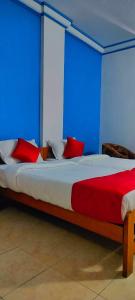una camera da letto con un letto con cuscini rossi di HOTEL MANHATTAN a Chennai