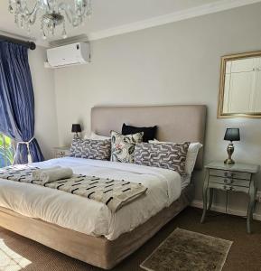 Un dormitorio con una cama grande y una lámpara de araña. en The Whale's Tale Guesthouse en Hermanus