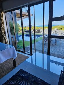 a room with a table and a view of a pool at The Whale's Tale Guesthouse in Hermanus