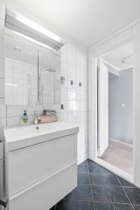 a white bathroom with a sink and a shower at Beautiful space with balcony in Oslo