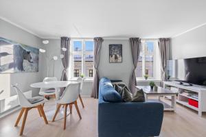 Beautiful space with balcony في أوسلو: غرفة معيشة مع أريكة زرقاء وطاولة