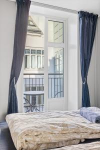 a bedroom with a bed and a large window at Beautiful space with balcony in Oslo