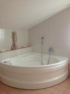 una grande vasca da bagno bianca in una stanza di Beb Villa Aurora a Carmagnola