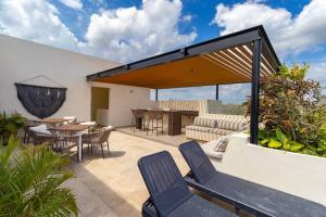 an outdoor patio with chairs and a table and a couch at Maranay 2 Story 3BR Penthouse in La Veleta in Tulum