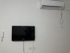 a flat screen tv hanging on a white wall at Sousse Beach Appartment FAMILY ONLY in Hammam Sousse