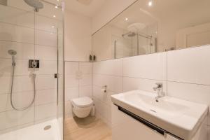 ein Bad mit einer Dusche, einem Waschbecken und einem WC in der Unterkunft Ferienwohnung Pusteblume - Villa Stranddistel in Binz
