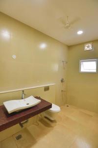 a bathroom with a sink and a toilet at Avenue 11 Boutique Residences, Poes Garden Chennai in Chennai
