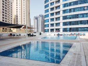 a large swimming pool in a city with tall buildings at Frank Porter - Dorra Bay in Dubai