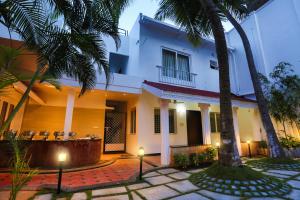 a house with palm trees in front of it at Avenue 11 Boutique Residences, Poes Garden Chennai in Chennai