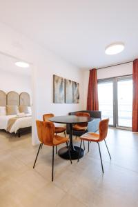 sala de estar con mesa, sillas y cama en Sea Sense Suite 8 en Bari