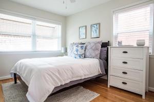 a bedroom with a white bed and a dresser at Transit-Friendly Home Old Town Parking in Alexandria