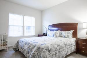Un dormitorio con una cama grande y una ventana en Large MD Townhome mins to UMD & DC Parking, en Greenbelt