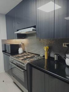 a kitchen with a stove and a counter top at Quite and Cozy in Seeb