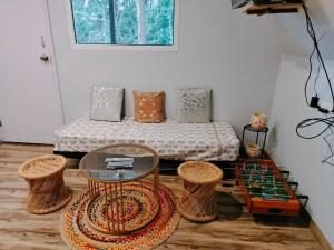 a room with a bed with a glass table and stools at IInfinity Kodaikanal in Kūkkāl