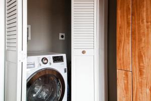 a washing machine in a room next to a door at Eastern Market Carriage house efficiency PRIVACY in Washington, D.C.