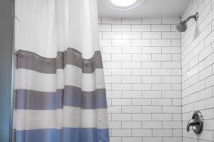 a shower with a striped shower curtain in a bathroom at Eastern Market Carriage house efficiency PRIVACY in Washington, D.C.