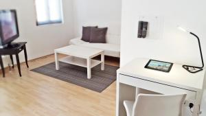 ein Wohnzimmer mit einem weißen Tisch und einem weißen Sofa in der Unterkunft Alte Uhrmacherei Eisenach in Eisenach