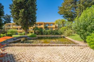 a garden with a pond in front of a building at Spacieux 3 pieces a 5 min des plages in Antibes