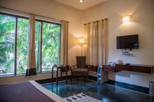 a hotel room with a bed and a desk and a tv at Hotel Ranthambore Regency in Sawāi Mādhopur