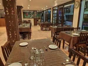 a dining room with tables and chairs and a restaurant at Hotel De Regency in Pelling