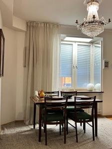 a dining room table with chairs and a chandelier at City Center Residence - 64 m2 St Eriksplan in Stockholm