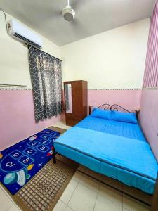 ein Schlafzimmer mit einem blauen Bett in einem rosa Zimmer in der Unterkunft Homestay Hitech Kulim Islam Guest Only in Kulim