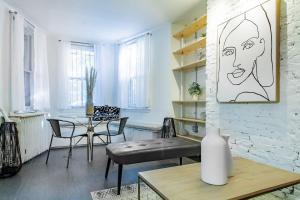 a living room with a table and chairs and a drawing on the wall at DesignerFlat Nestled Between Dupont&Logan Circles in Washington, D.C.