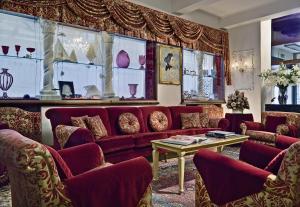 a living room with a red couch and a table at Hotel Giorgione in Venice