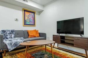 a living room with a couch and a flat screen tv at A Classy Corner of DC Minutes walk to Dupont Circle in Washington