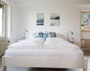 un letto bianco in una camera da letto con pareti bianche di Hus im Schwefelmättle, Hinterzarten a Hinterzarten