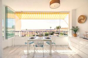a dining room with a table and chairs and a large window at PENTHOUSE BELLAVISTA with SEA VIEWS in Torrevieja