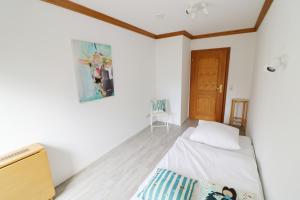 a bedroom with a bed and a painting on the wall at Hus im Schwefelmättle, Hinterzarten in Hinterzarten