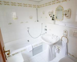 a white bathroom with a tub and a sink at Hus im Schwefelmättle, Hinterzarten in Hinterzarten
