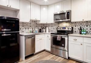 a kitchen with white cabinets and stainless steel appliances at Fantastic Falls Church HomeBase for DC area travel in Arlington +9 photos