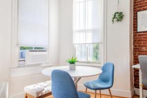 a dining room with a white table and blue chairs at Classy 1-BR Flat Nestled Between Dupont & Logan in Washington, D.C. +5 photos